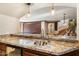 Basement wet bar with granite countertops, sink, and view into large recreation room with ping pong table at 11988 E Larkspur Dr, Scottsdale, AZ 85259