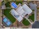 Stunning aerial view of the modern home, showcasing its pool, landscaping, and a full basketball court at 12034 N 61St St, Scottsdale, AZ 85254