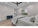 Bright bedroom features a ceiling fan, a window view, and a modern aesthetic with neutral tones and wooden floors at 12034 N 61St St, Scottsdale, AZ 85254
