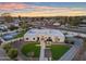 Stunning modern home with a minimalist design, manicured lawn and beautiful desert landscaping at sunset at 12034 N 61St St, Scottsdale, AZ 85254