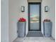 Inviting front entrance with a modern door, elegant lighting fixtures, and potted red flowers at 12034 N 61St St, Scottsdale, AZ 85254