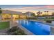Serene pool area with modern design, lush greenery, and a covered patio for relaxed outdoor living at 12034 N 61St St, Scottsdale, AZ 85254