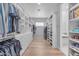 Spacious walk-in closet with custom shelving, cabinets, and hardwood floors for optimal organization at 12034 N 61St St, Scottsdale, AZ 85254