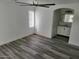 Bedroom with gray wood-look floors, ceiling fan, and connected bathroom with updated vanity at 12917 W Willow Ave, El Mirage, AZ 85335