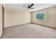 Bedroom with a ceiling fan, comfortable carpet, and a window with backyard views at 13202 N 98Th Dr, Sun City, AZ 85351