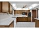 Well-lit kitchen featuring white countertops, wooden cabinets, and modern appliances at 13202 N 98Th Dr, Sun City, AZ 85351