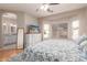 Light-filled bedroom with wood floors, ceiling fan, and ensuite bathroom access at 14212 W Weldon Ave, Goodyear, AZ 85395