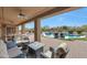 Covered patio with seating area overlooking lush backyard and sparkling pool at 14507 W Christy Dr, Surprise, AZ 85379