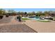 A well landscaped backyard featuring a pool, seating areas, stone features, and artificial turf at 14507 W Christy Dr, Surprise, AZ 85379
