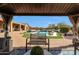 Charming backyard view from the gazebo, showcasing the pool, lush landscaping, and inviting outdoor space at 14507 W Christy Dr, Surprise, AZ 85379