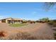 A spacious desert landscaped backyard featuring a gazebo, green lawn, and views of the home's exterior at 14507 W Christy Dr, Surprise, AZ 85379