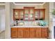 Built in bar area features wood cabinets, a marble counter, tiled backsplash and glass front upper cabinets at 14507 W Christy Dr, Surprise, AZ 85379