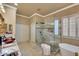 A luxurious bathroom with a glass shower, soaking tub, and dual vanity at 14507 W Christy Dr, Surprise, AZ 85379