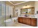 Bathroom featuring a soaking tub, a walk-in shower, and decorative lighting at 14507 W Christy Dr, Surprise, AZ 85379