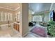 Bright bathroom featuring soaking tub, chandelier, wood vanity and decorative mirror at 14507 W Christy Dr, Surprise, AZ 85379