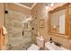 Bathroom featuring a frameless glass shower, toilet, sink, and decorative framed mirror at 14507 W Christy Dr, Surprise, AZ 85379