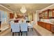 Open dining area with a marble table, upholstered chairs, chandelier, and a view to the kitchen at 14507 W Christy Dr, Surprise, AZ 85379