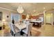 This dining area features a marble table, upholstered chairs, a chandelier, and a view to the kitchen at 14507 W Christy Dr, Surprise, AZ 85379