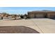 Spacious driveway leading to a three-car garage, surrounded by desert landscaping at 14507 W Christy Dr, Surprise, AZ 85379