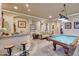 Spacious game room featuring a pool table, wet bar with barstools, and a comfortable seating area at 14507 W Christy Dr, Surprise, AZ 85379
