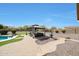 A backyard gazebo offering a tranquil outdoor seating area with beautiful landscaping and stone path at 14507 W Christy Dr, Surprise, AZ 85379