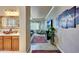 Hallway with warm color tones leading from the bathroom to a living room at 14507 W Christy Dr, Surprise, AZ 85379