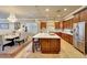 A gourmet kitchen boasts a large island, stainless steel appliances, and adjoining dining area with elegant chandelier at 14507 W Christy Dr, Surprise, AZ 85379
