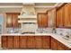 Gourmet kitchen with custom hood, gas range cooktop, and quartz countertops with subway tile at 14507 W Christy Dr, Surprise, AZ 85379
