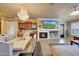 Living room with fireplace, built-in shelves, tv, dining table and bar area at 14507 W Christy Dr, Surprise, AZ 85379