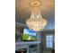 Cozy living room with fireplace, mounted TV, and a crystal chandelier at 14507 W Christy Dr, Surprise, AZ 85379