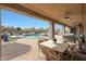 A covered patio with ceiling fan, outdoor dining area and a view of the backyard pool and gazebo at 14507 W Christy Dr, Surprise, AZ 85379
