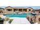Inviting backyard pool area features lounge seating, rock accents, and a covered patio for relaxing and entertaining at 14507 W Christy Dr, Surprise, AZ 85379