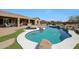 Beautiful pool with a rock waterfall feature and artificial turf, creating a backyard oasis for relaxation and entertainment at 14507 W Christy Dr, Surprise, AZ 85379