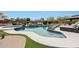 Custom designed pool with rock features, a spa, and plenty of space for outdoor lounging at 14507 W Christy Dr, Surprise, AZ 85379
