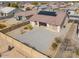 Aerial view of home with solar panels, backyard with rock landscaping, and block wall for maximum privacy at 1629 E Prickly Pear Pl, Casa Grande, AZ 85122