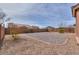 A spacious backyard with rock landscaping, mature foliage, and an enclosed block wall, perfect for outdoor activities at 1629 E Prickly Pear Pl, Casa Grande, AZ 85122