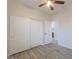 A bedroom features a ceiling fan, a closet, and a view of the bathroom at 1629 E Prickly Pear Pl, Casa Grande, AZ 85122