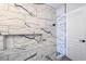 Modern shower with white and black marble-look tiles, built-in niche, and sleek fixtures at 1629 E Prickly Pear Pl, Casa Grande, AZ 85122