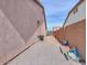 A side yard featuring low maintenance rock landscaping, block fencing, and storage space for outdoor equipment at 1629 E Prickly Pear Pl, Casa Grande, AZ 85122