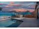 This backyard has a pool, hot tub, and outdoor bar under cafe lights with mural-covered walls at 1700 W Paisley Dr, San Tan Valley, AZ 85144