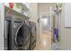 Laundry room includes a washer, dryer, shelving, and access to other rooms at 1700 W Paisley Dr, San Tan Valley, AZ 85144