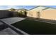 Backyard featuring a tiled patio, privacy wall and strip of artificial turf at 17168 W Middlebury St, Surprise, AZ 85388
