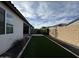 A backyard features artificial turf, rock borders, and a tan block wall at 17168 W Middlebury St, Surprise, AZ 85388