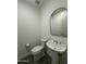 Small bathroom featuring a stylish pedestal sink and sleek, arched mirror at 17168 W Middlebury St, Surprise, AZ 85388