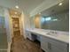 Modern bathroom with double sinks, gray cabinets, white marble countertops, glass shower, and walk-in closet access at 17168 W Middlebury St, Surprise, AZ 85388