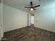 This bedroom has a neutral decor, fan, tiled floor, and an open door to another room at 17168 W Middlebury St, Surprise, AZ 85388