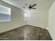 Bedroom with wood-look tile floors, ceiling fan, and bright natural light at 17168 W Middlebury St, Surprise, AZ 85388
