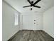 Bedroom with stylish wood-look tile flooring, ceiling fan, and ample natural light at 17168 W Middlebury St, Surprise, AZ 85388