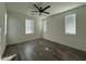 Spacious bedroom with wood-look tile flooring, neutral paint, a ceiling fan and bright windows at 17168 W Middlebury St, Surprise, AZ 85388