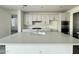 Bright kitchen showcasing white cabinets, a large island, stainless steel appliances, and a view into the adjacent living space at 17168 W Middlebury St, Surprise, AZ 85388